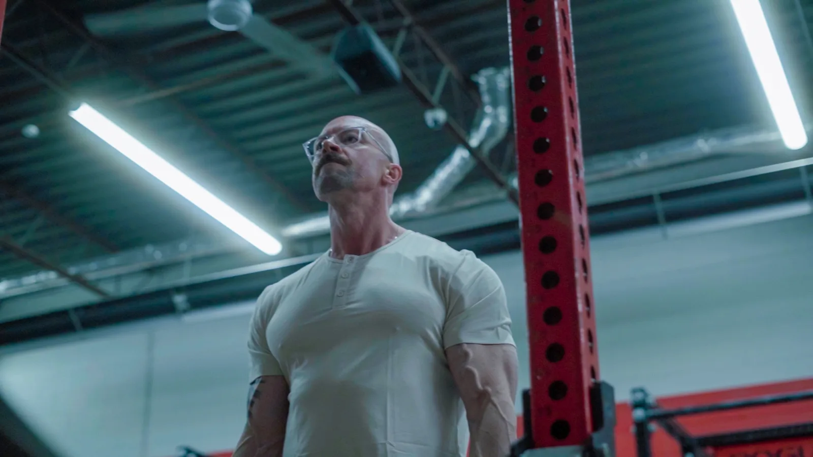 Tyson under harsh overhead gym lights, head tipped back, mid-effort