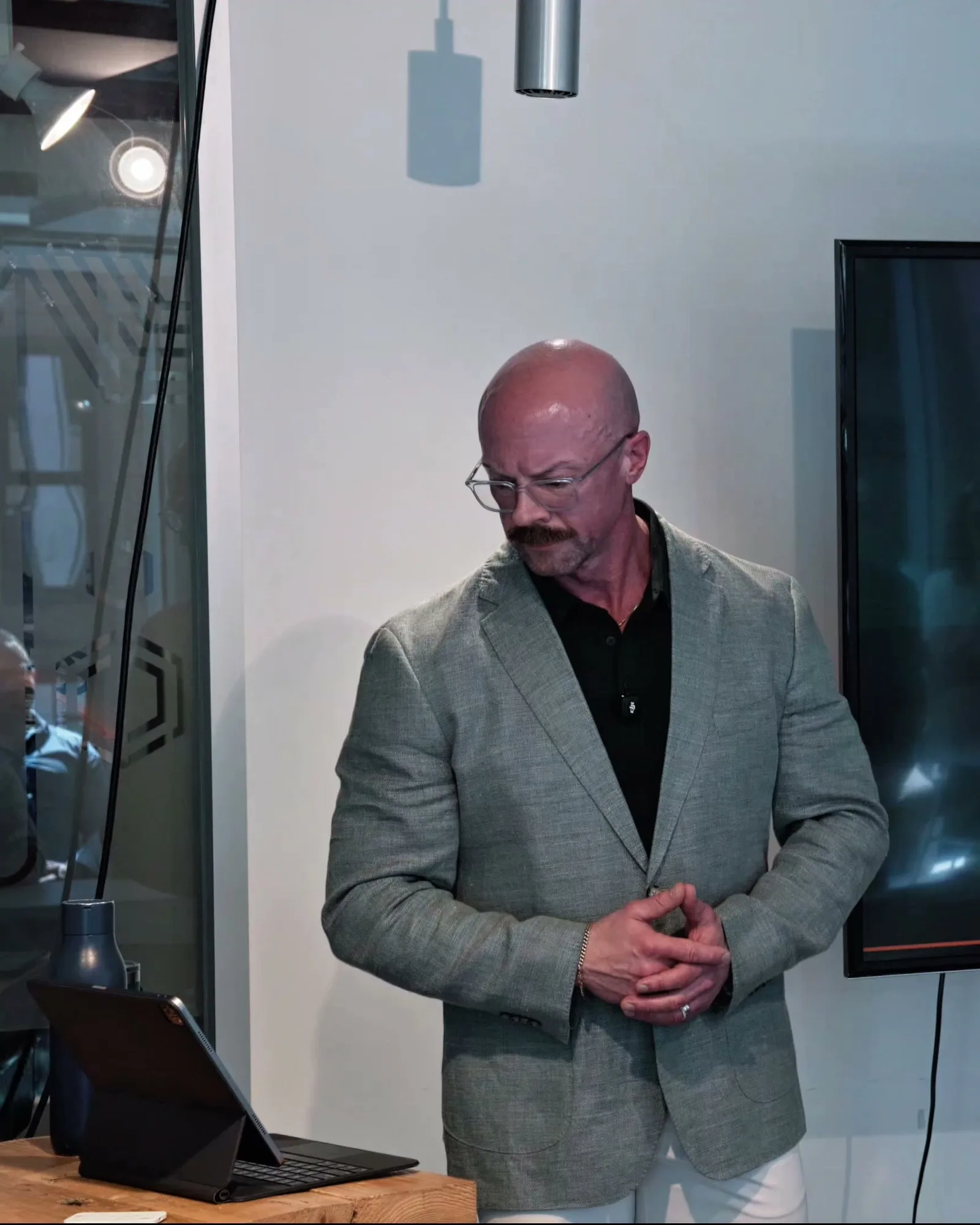 Tyson at the lectern during his keynote, hands clasped, head down