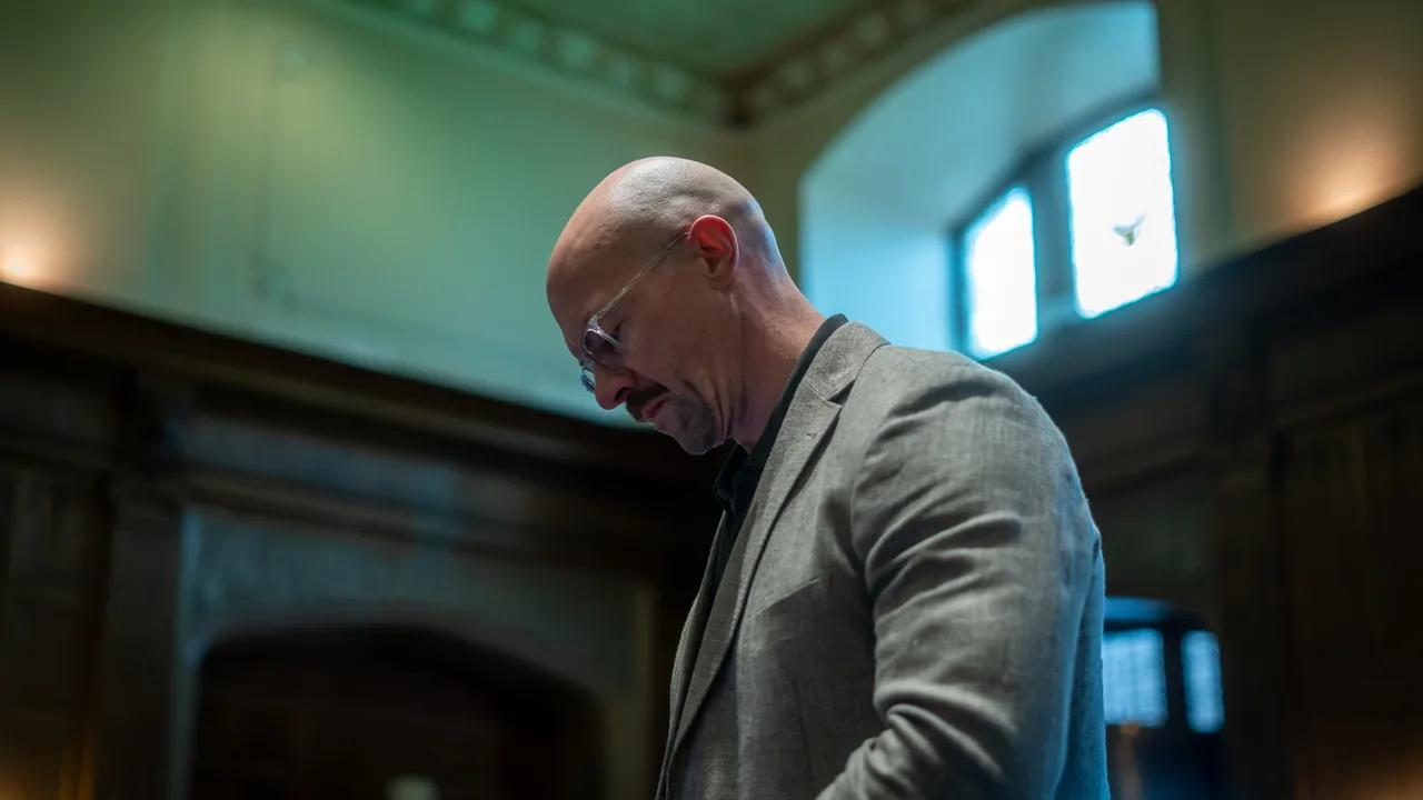 Tyson DesMarais alone in a heritage hall, head lowered, before he speaks.